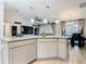 View of an open-concept kitchen with an island, light gray cabinets, and dining and living spaces at 420 Ketch Rd, St Cloud, FL 34771
