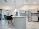 Modern kitchen featuring gray cabinets, stainless steel appliances, granite countertops, and an adjacent dining area at 420 Ketch Rd, St Cloud, FL 34771