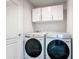 Laundry room featuring a side-by-side Samsung washer and dryer, and white cabinets at 420 Ketch Rd, St Cloud, FL 34771