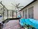 Relaxing screened patio with brick floors, a large ceiling fan, and comfortable seating with blue cushions at 420 Ketch Rd, St Cloud, FL 34771