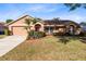Charming single-story home with a well-manicured lawn, front garden, and attached two-car garage at 4216 Gold Rush Ln, St Cloud, FL 34772
