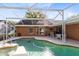 View of the screened pool with the pool cleaner and a look at the home's back windows at 4216 Gold Rush Ln, St Cloud, FL 34772