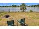 Backyard view of lake with two chairs and fire pit at 4343 Lake Richmond Dr, Orlando, FL 32811