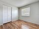 Inviting bedroom featuring wood-look flooring, a window, and a closet with bi-fold doors at 4343 Lake Richmond Dr, Orlando, FL 32811