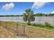 A view of the lake beyond a chain link fence at 4343 Lake Richmond Dr, Orlando, FL 32811
