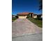 Inviting single-story home featuring a barrel tile roof and a brick paver driveway at 448 Cinnamon Dr, Kissimmee, FL 34759