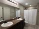 Bathroom featuring double sinks, large vanity, shower, and tile flooring at 4490 Sw 169Th Pl, Ocala, FL 34473