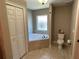 Bright bathroom featuring a soaking tub with tile surround and a linen closet at 4490 Sw 169Th Pl, Ocala, FL 34473