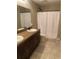 Bathroom with dual sinks, a granite countertop, and a shower featuring a white curtain at 4490 Sw 169Th Pl, Ocala, FL 34473