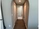 Hallway featuring neutral walls, arched entrance, and two storage closets at the sides at 4490 Sw 169Th Pl, Ocala, FL 34473