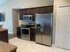 Kitchen featuring stainless steel appliances, tiled floor, dark wood cabinets, and granite countertops at 4490 Sw 169Th Pl, Ocala, FL 34473