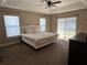 Tranquil primary bedroom featuring large windows, slider doors, and tray ceilings at 4490 Sw 169Th Pl, Ocala, FL 34473