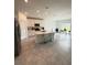 Open-concept kitchen with white cabinets, stainless appliances, island with seating and breakfast nook at 4812 Worchester Dr, Kissimmee, FL 34746