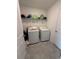 Convenient laundry room featuring a washer, dryer, and shelf for storage at 4812 Worchester Dr, Kissimmee, FL 34746