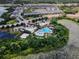 Aerial view of community pool, clubhouse, and amenities area surrounded by beautiful landscaping and lake at 510 Captiva Dr, Davenport, FL 33896