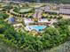 Overhead view of a community pool, amenities, and residences amidst a lush, green landscape at 510 Captiva Dr, Davenport, FL 33896