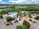 Aerial view of clubhouse and pool area with manicured lawns, ample parking, and palm trees at 510 Captiva Dr, Davenport, FL 33896