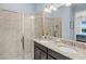 A bright bathroom featuring a dual sink granite vanity and tiled walk-in shower at 510 Captiva Dr, Davenport, FL 33896