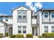 Two-story townhome exterior featuring white stucco, a gray accent trim, and well-maintained landscaping at 510 Captiva Dr, Davenport, FL 33896