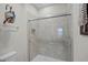 Shower featuring tiled walls, glass door, and built-in niche, blending style and functionality at 510 Captiva Dr, Davenport, FL 33896