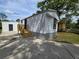 Exterior of home featuring driveway, wood deck with stairs, and white siding at 5161 Howison Rd, Kissimmee, FL 34746