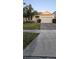 Charming single-story home with manicured lawn, mature trees, and a brick-paved driveway at 5340 Jubiloso Dr, St Cloud, FL 34771