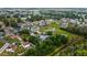 Aerial view of a neighborhood featuring a wide view of lush greenery, beautiful homes, and a small lake in the distance at 572 Nogales Ct, Kissimmee, FL 34758