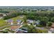 Aerial view of a quiet neighborhood showcases a house with screened pool, green space, and mature trees surrounding the residences at 572 Nogales Ct, Kissimmee, FL 34758