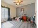 Cozy bedroom with grey accent wall, ceiling fan and a charming window dressed with leafy decor at 572 Nogales Ct, Kissimmee, FL 34758