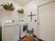 Well-lit laundry room with modern washer and dryer, shelving and decor at 572 Nogales Ct, Kissimmee, FL 34758