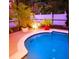 Inviting screened-in pool area with lush tropical plants, patio and overhead lighting at 572 Nogales Ct, Kissimmee, FL 34758