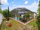 Enclosed pool featuring mature tropical landscaping and screened enclosure at 572 Nogales Ct, Kissimmee, FL 34758