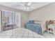 Cozy bedroom featuring tiled floors, a ceiling fan, and a comfortable bed with a patterned blanket at 5912 Village Cir # Ge, Orlando, FL 32822