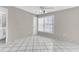 This bedroom features neutral walls, tiled floor, and a bright window to let natural light flood in at 5912 Village Cir # Ge, Orlando, FL 32822