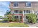 Inviting townhouse with a well maintained lawn and blooming bushes near the entryway at 5912 Village Cir # Ge, Orlando, FL 32822