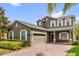 Charming two-story home with brick driveway, attached garage, manicured shrubs, and white shutters at 6137 Waterside Island Ln, Winter Garden, FL 34787