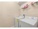 Laundry room featuring white washer, dryer, and storage shelf at 6137 Waterside Island Ln, Winter Garden, FL 34787