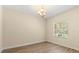 Room features bright window, neutral walls, chandelier, and new wood floor at 6137 Waterside Island Ln, Winter Garden, FL 34787
