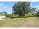 Home backyard featuring a large shade tree and fire pit in a spacious grassy area at 6186 Oak Shore Dr, St Cloud, FL 34771