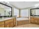 Primary bathroom featuring double sinks, a corner tub, and tiled walls at 6186 Oak Shore Dr, St Cloud, FL 34771