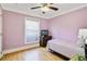 Cozy bedroom with wood floors, lavender walls and a small TV on the dresser at 6186 Oak Shore Dr, St Cloud, FL 34771