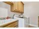 Laundry room with a white washer and dryer, utility sink and built-in cabinets at 6186 Oak Shore Dr, St Cloud, FL 34771