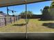 Large backyard featuring a wood fence, lush lawn, and three palm trees at 633 Cypress Tree Ct, Orlando, FL 32825