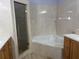 Bright bathroom featuring a glass enclosed shower, soaking tub, and tiled walls at 633 Cypress Tree Ct, Orlando, FL 32825