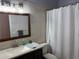 Bathroom featuring updated vanity, decorative mirror, and tiled shower at 633 Cypress Tree Ct, Orlando, FL 32825