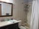 Bathroom featuring updated vanity, decorative mirror, and tiled shower at 633 Cypress Tree Ct, Orlando, FL 32825