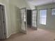 Spacious bedroom with French doors, neutral carpet, and large windows at 633 Cypress Tree Ct, Orlando, FL 32825
