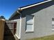 Exterior view of home showing a gray stucco finish, white trim and a gated yard at 633 Cypress Tree Ct, Orlando, FL 32825