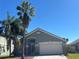 Charming single-Gathering home featuring a two-car garage, manicured lawn, and mature palm trees in a sunny neighborhood at 633 Cypress Tree Ct, Orlando, FL 32825