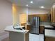 Bright kitchen featuring stainless steel appliances, tile flooring, ample storage, and a breakfast bar at 633 Cypress Tree Ct, Orlando, FL 32825